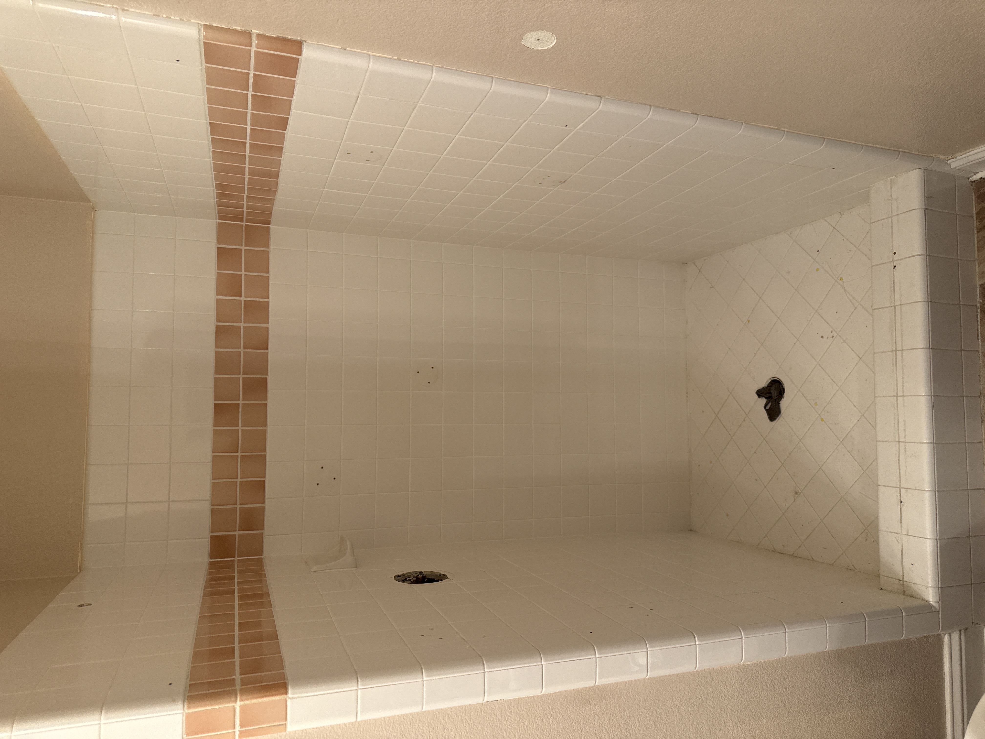 Discolored shower tile before professional reglazing in Bay Area bathroom