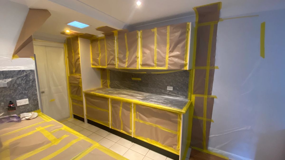 Kitchen masked with paper and tape before cabinet spraying