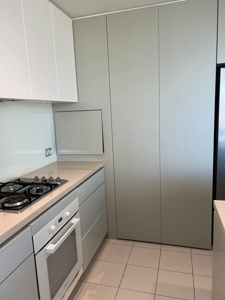 Wood-veneer pantry and base cabinets after painting